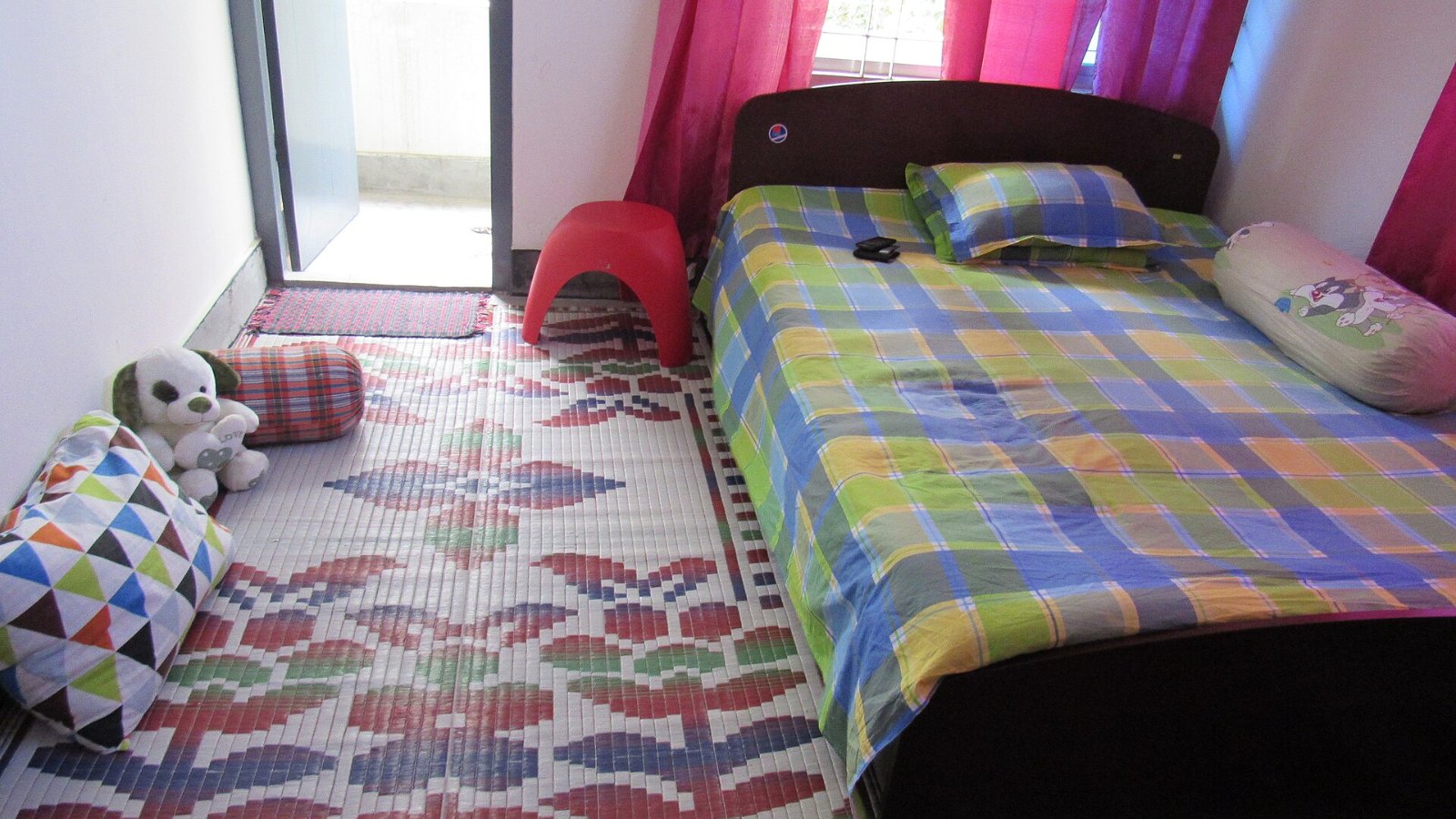 A simple bedroom with a made bed and pillows