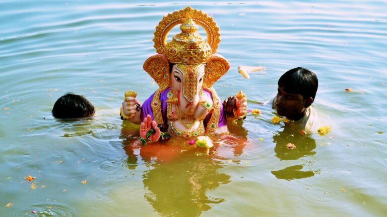 A Ganesh idol being carried into the water for visarjan at Futala lake, Nagpur