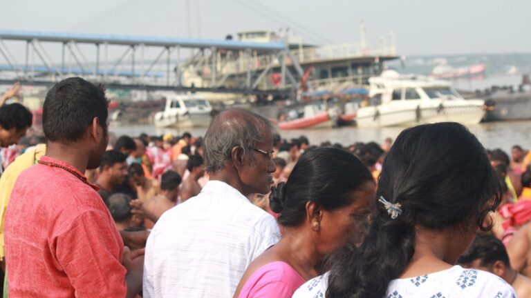 Families gathered at a river ghat during Mahalaya to offer tarpan in remembrance of ancestors
