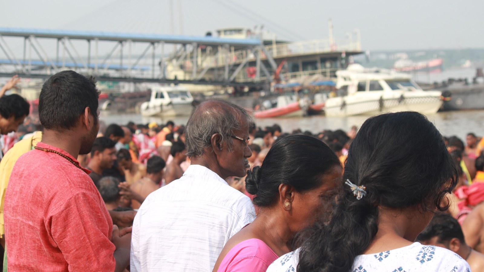 Families gathered at a river ghat during Mahalaya to offer tarpan in remembrance of ancestors